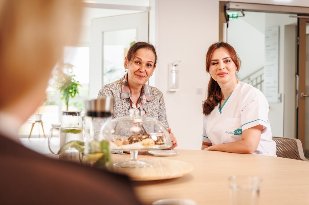 Seniorin und Pflegefachkraft bei einer gemeinsamen Mahlzeit in Erlensee
