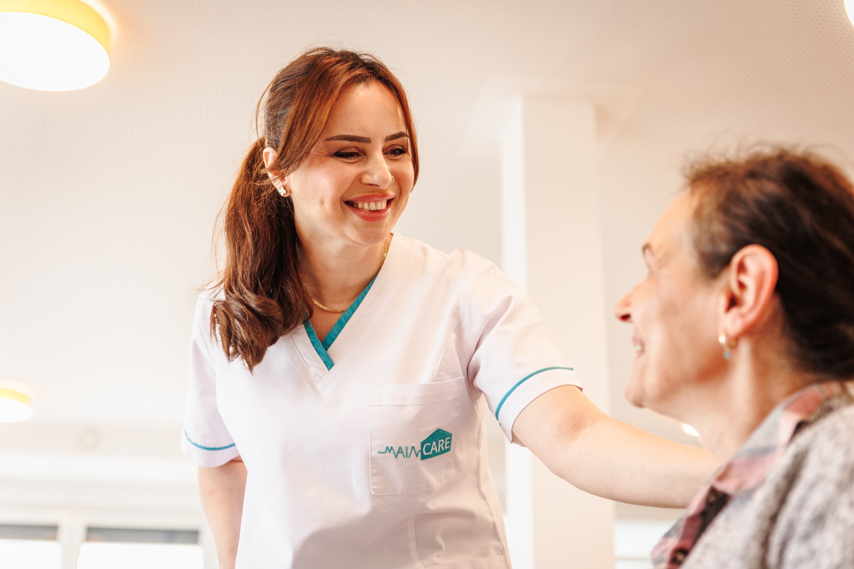 Main Care Pflegefachkraft betreut eine Patientin in der Intensivpflege