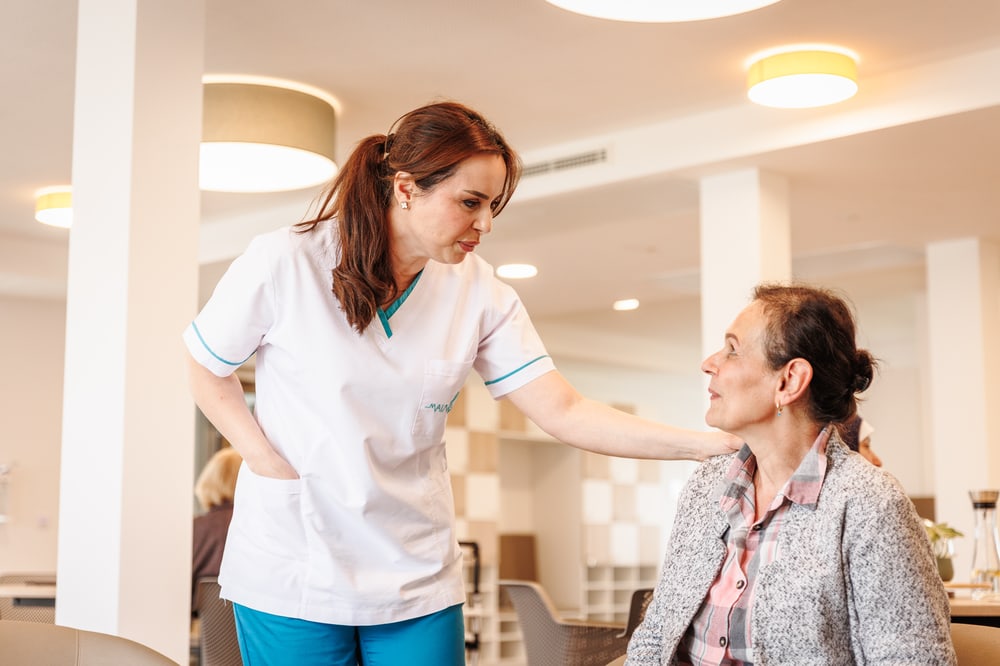 Pflegefachkraft begleitet eine Patientin in der außerklinischen Intensivpflege