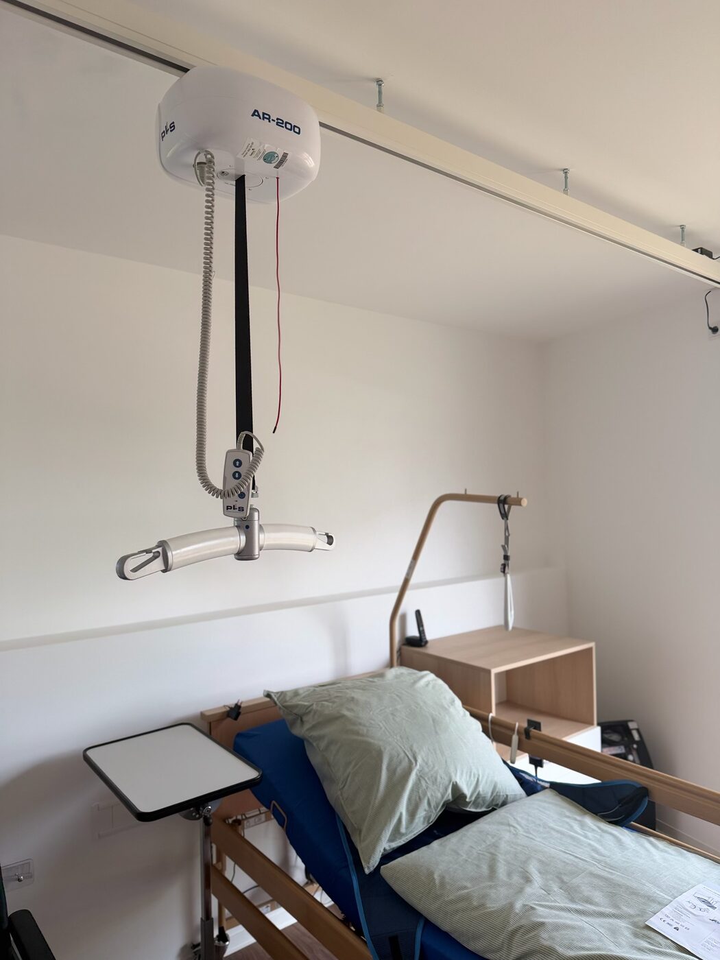 Moderner Deckenlifter über dem Pflegebett in einem Intensivpflege-Apartment